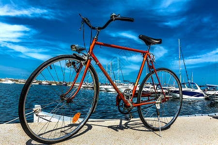 橙色自行车轮子码头天空海滨橙子蓝色车轮背景图片