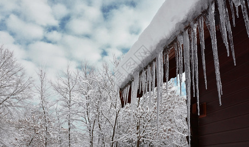 屋顶的雪带有冰柱的冬季场景背景
