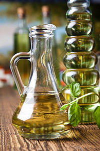橄榄油和橄榄 地中海农村主题宏观叶子油壶营养草药处女香料木头液体玻璃背景图片
