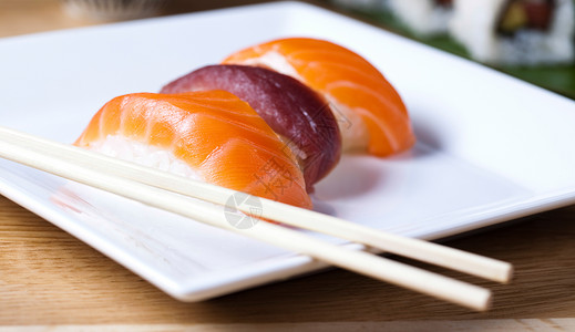 日本混合寿司 东方烹饪主题多彩美味筷子鱼片厨房黄瓜海藻盘子桌子竹子午餐背景图片