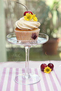 蛋糕樱桃花与樱桃花和鲜花的杯饼磨砂小吃糕点花瓣桌子家庭烘焙杯子香草工作室背景