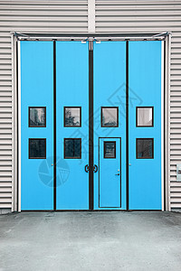 一座仓库大楼上的蓝色停车场门高清图片