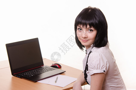 拿着笔记本电脑坐在桌子上的女孩背景图片