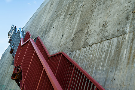 水泥护栏灰水泥墙上的金属楼梯扶手蓝色材料石膏石墙护栏航班栏杆石头平台背景