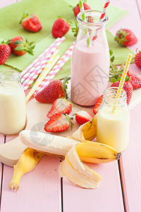 牛奶加新鲜草莓和香蕉奶制品砧板茶点浆果木板稻草瓶子乳制品奶瓶乡村背景图片