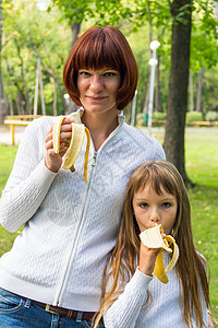 母亲和女儿吃香蕉孩子家庭女学生白色女士父母女性童年背景图片