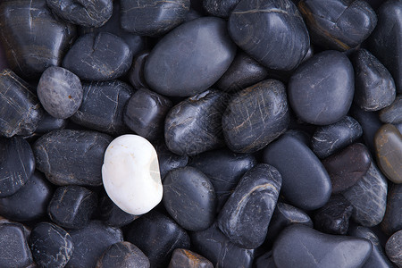 个性概念黑色侵蚀水渍多样性石英鹅卵石例外少数民族领导矿物背景图片