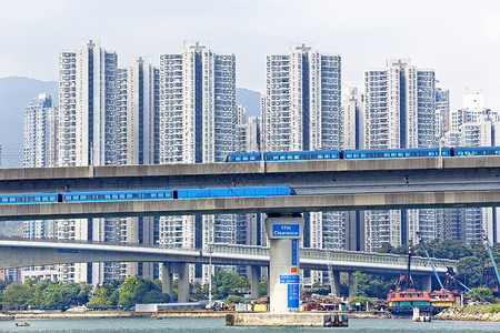 漆香桥香港市市区桥上高速火车 车速超快运输财产绿色城市土地天空单轨蓝色高楼住宅背景