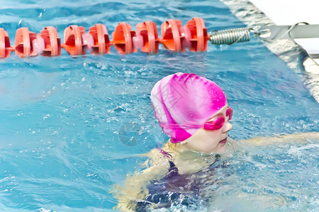 游泳池的可爱女孩强光孩子水池女学生运动童年游泳白色背景图片