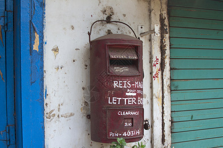传统的红红色旧印度邮箱 印度果阿金属邮票建筑学运输标准盒子信封邮政古董送货背景图片