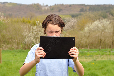 女孩使用数字平板电脑女性笔记本花园工作药片闲暇互联网背景图片