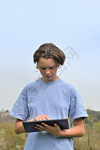 女孩使用数字平板电脑闲暇笔记本药片互联网工作女性花园背景图片