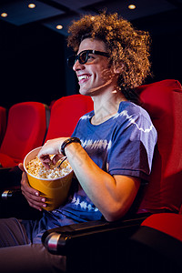 年轻人在看一部3D电影礼堂活动电影业闲暇椅子微笑爆米花演出电影院男性背景图片