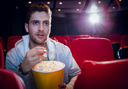 年轻人在看电影震惊娱乐礼堂电影业椅子演出红色时间文艺男性背景图片