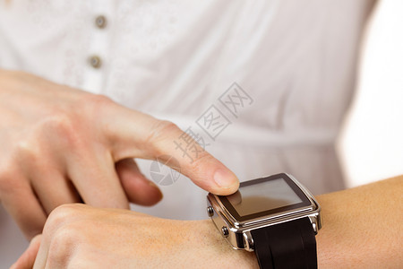 女人用聪明的手表设备移动休闲手腕服装计算女士女性技术电脑背景图片