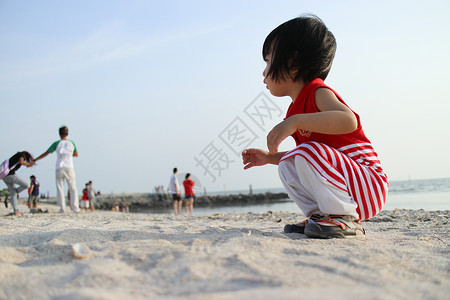 亚裔中国儿童玩沙沙孤独童年女孩海滩海滨孩子们孩子背景图片