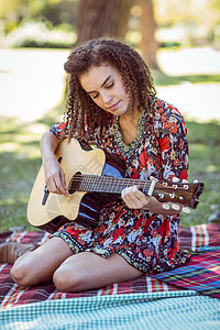 快乐的女孩弹吉他闲暇草地头发阳光吉他棕色女士农村绿色女性背景图片