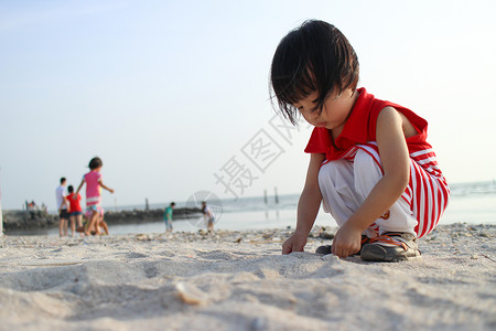 亚裔中国儿童玩沙沙孤独孩子孩子们童年海滨海滩女孩背景图片