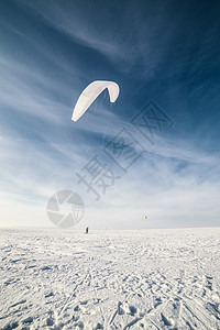 雪上放着蓝风筝的滑板机冲浪跳跃太阳男性行动冒险闲暇飞行蓝色浪板背景