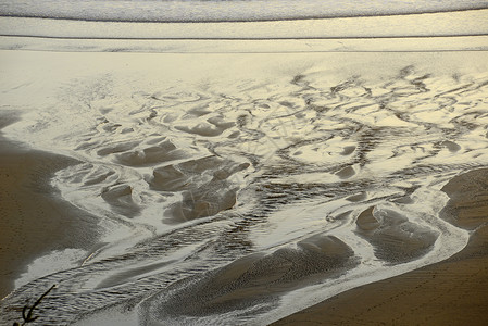 沙子上水的形态海滩辉光海岸橙子流动曲线背景图片