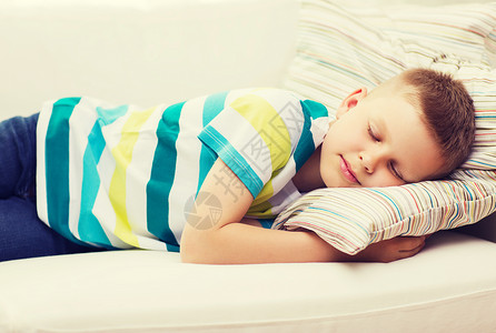小男孩睡在家里睡觉休息沙发福利枕头说谎长椅青春期小憩男生微笑背景