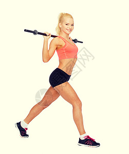微笑着运动的女子用巴铃锻炼力量培训师训练弓步运动装身体肌肉减肥运动员二头肌背景图片