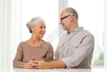 在家沙发上坐着幸福的老年情侣桌子闲暇家庭房间祖父快乐祖母丈夫妻子男人背景图片