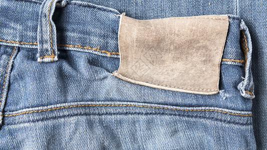Jean 裤子上的标签皮革衣服材料牛仔布纺织品织物棉布黄色服饰服装背景图片