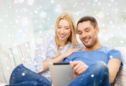 在家带着平板电脑的幸福快乐情侣说谎夫妻男朋友家庭房间男人技术药片长椅闲暇背景图片