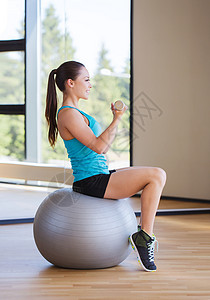 带着哑铃和练球的笑着女人锻炼有氧运动肌肉损失女士训练平衡女性运动重量背景图片