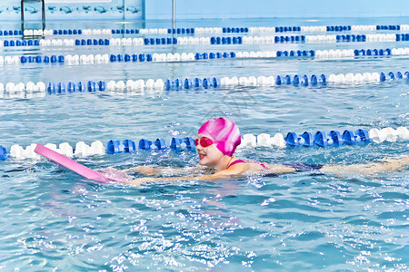 游泳池的可爱女孩水池童年孩子强光运动女学生白色游泳背景图片