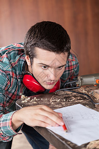 男人在看飞机财产工具工人建造绘画木匠铅笔听力男性木材背景图片