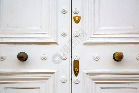 红色铜钉和光亮的黄铜制铜甲建筑学入口装饰品门把手文化艺术戒指安全古董房子背景图片