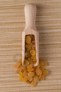 带金葡萄干的木制勺子美食团体葡萄干小吃食物店铺饮食水果框架金子背景图片