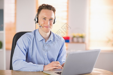 使用耳机打来电话的偶然商务人士职场男性电脑人士呼叫沟通技术笔记本客户服务无线的高清图片素材