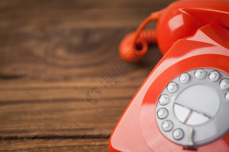 木制桌上的红色电话拨号固定电话橡木木头桌子背景图片
