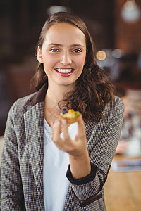 微笑的年轻女士 展示松饼头发店铺咖啡屋潮人餐厅食物行业休息闲暇咖啡馆背景图片