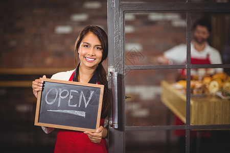 咖啡店黑板微笑的女服务员展示有开放标志的黑板咖啡师饮料制服行业在职员工男人女性咖啡馆食品背景