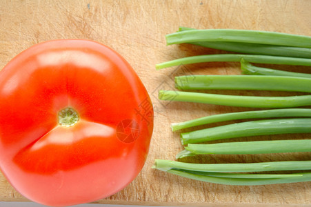 切削板上的蔬菜绿色香葱盘子红色小吃木头菜板食物背景图片
