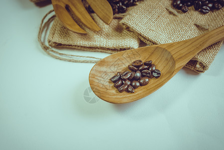 放在麻布上的木勺和咖啡豆咖啡豆木勺和麻袋表面的叉子粮食咖啡麻布木头勺子解雇食物美食棕色背景