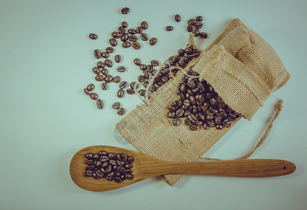放在麻布上的木勺和咖啡豆复古的木制的高清图片