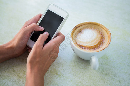 有卡布奇诺 使用手机的女人咖啡屏幕餐厅闲暇商业技术咖啡屋食品杯子饮料背景图片