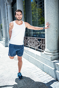 从事腿伸展的英俊运动员调子反思跑表竞技运动风光运动服城市生活拉伸护理背景图片