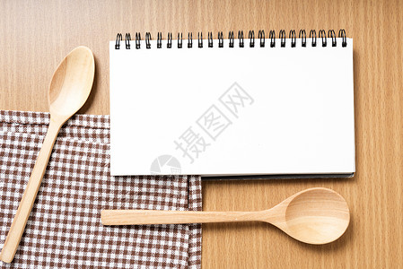 笔记本和厨房工具桌布棕色木板桌子日历白色烹饪勺子卡片食物背景图片