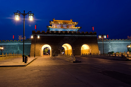 中国Qufu市夜间城墙门背景图片