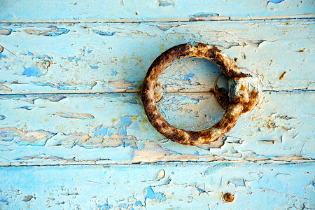 金属圈蓝木门和摩洛科敲门器中的生锈油漆螺栓锁孔木头隐私铰链指甲蓝色建筑学入口保障背景