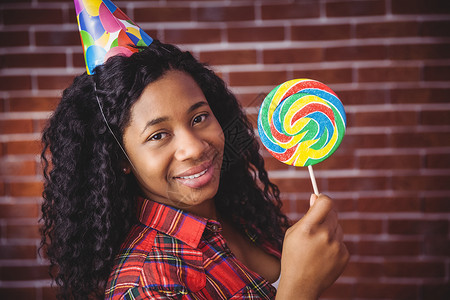 带有帽子和棒棒棒糖的可爱型号乐趣女性生日红砖服装休闲潮人女士派对卷发背景图片