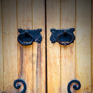 锁子甲红色铜钉和光亮的黄铜制铜甲建筑装饰品戒指城市入口建筑学安全艺术房子木头背景