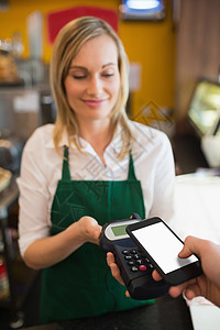 通过NFC接受报酬的女职工生意店铺电子饮料服务键盘设备支付浅色微笑背景图片