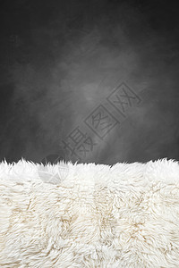 白色毛皮地毯和深灰漆黑的墙背景